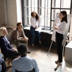 A woman presenting to a group of employees - Training Magazine
