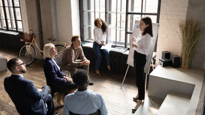 A woman presenting to a group of employees - Training Magazine