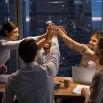 teammates high fiving each other in the office.