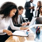 Concentrated,African,American,Woman,Doing,Paperwork,,Sitting,In,Modern,Office