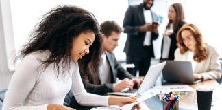 Concentrated,African,American,Woman,Doing,Paperwork,,Sitting,In,Modern,Office