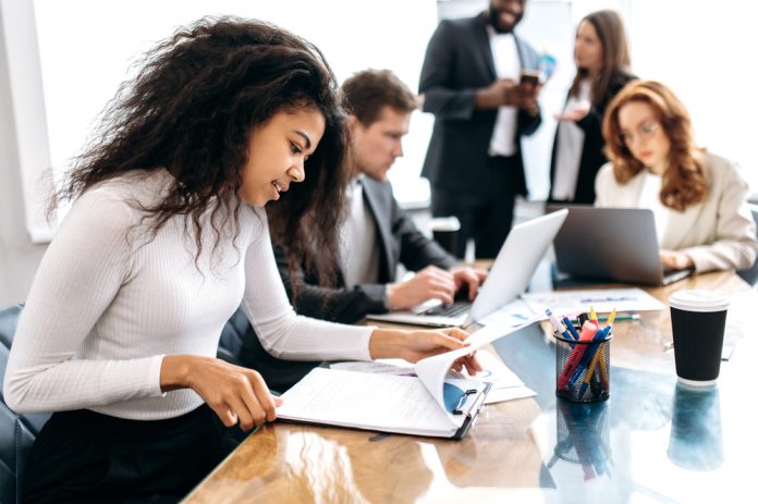 Concentrated,African,American,Woman,Doing,Paperwork,,Sitting,In,Modern,Office