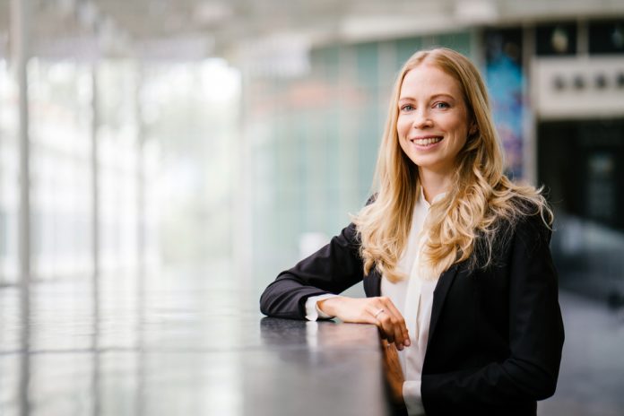 A,Russian,Woman,In,A,Suit,Leans,Against,A,Stone