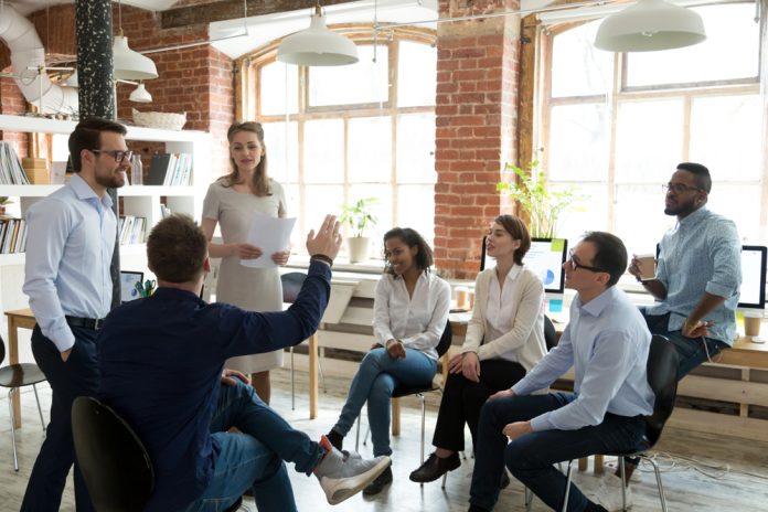 work colleagues sitting in a circle discussing something.