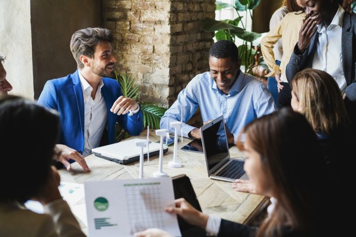 group of men and women sitting together and collaborating on a project.