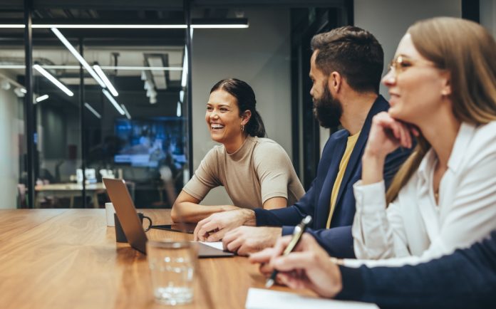 Happy,Businesswoman,Laughing,While,Leading,A,Meeting,With,Her,Colleagues.