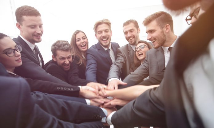 Large,Group,Of,Business,People,Standing,With,Folded,Hands,Together