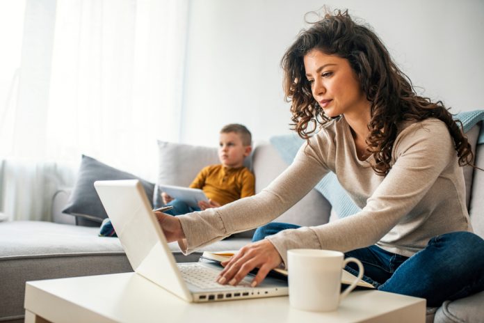 Smiling,Mom,Working,At,Home,With,Her,Child,On,The