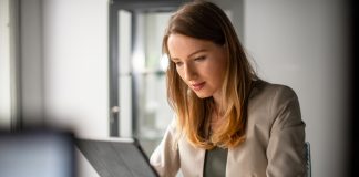 a young woman typing on her ipad.
