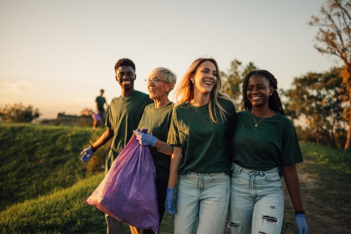 Four,Volunteers,Are,Walking,And,Carrying,Garbage,Bags,During,A