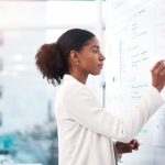 a woman standing in front of the whiteboard.