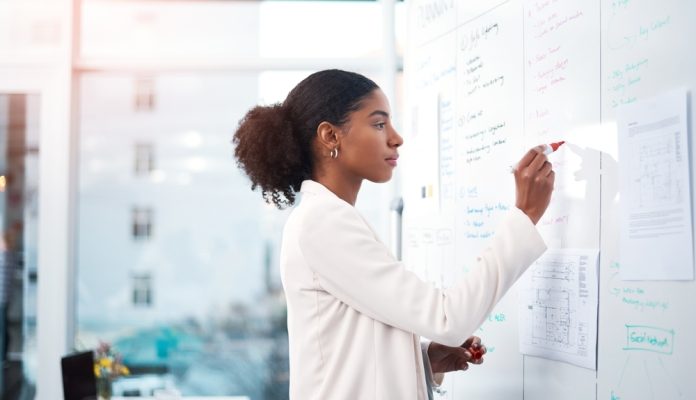a woman standing in front of the whiteboard.