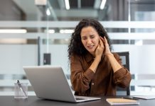 A woman at work dealing with ringing in her ear.