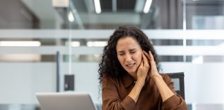 A woman at work dealing with ringing in her ear.