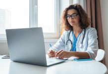What to Look for in a Virtual Healthcare Education Program a woman sitting at a desk with her lap top open.