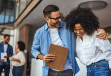 two colleagues laughing with each other.