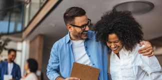 two colleagues laughing with each other.