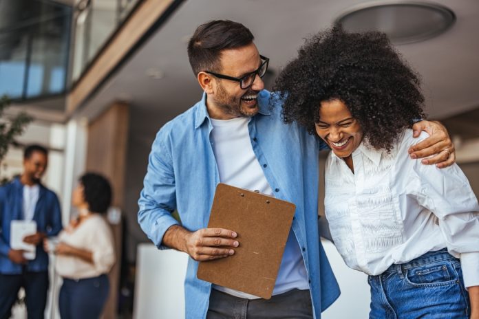 two colleagues laughing with each other.