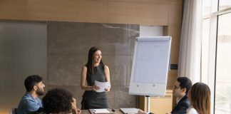 on the job training - a woman presenting in front of her colleagues.