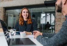 a red headed woman having coffee with a colleague