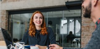 a red headed woman having coffee with a colleague