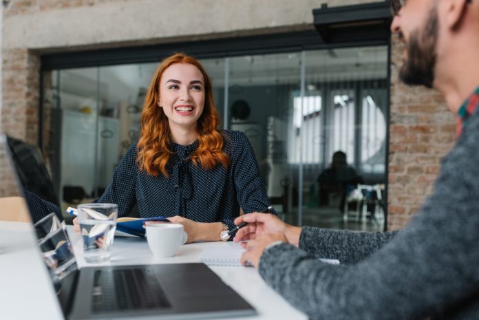 a red headed woman having coffee with a colleague