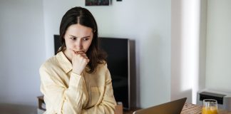 Young,Asian,Woman,Looking,Frustrated,At,A,Laptop,While,Holding