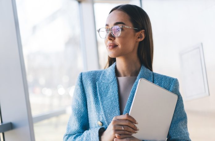Confident,Freelancer,Holding,Tablet,Near,Window,,Gazing,Thoughtfully,Outside,,Symbolizing