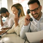 group of people working in an office handling phone calls