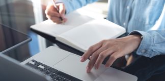 Business,Woman,Working,On,Laptop,Computer,And,Writing,Note,On