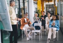 How to Apply the 70-20-10 Framework in a L&D Strategy Group,Of,Multiethnic,Colleagues,Smiling,While,Discussing,Business,Strategy,For