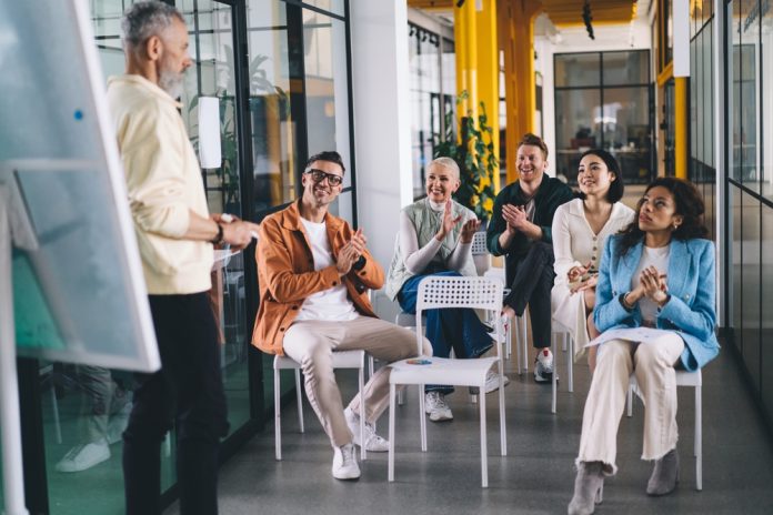 How to Apply the 70-20-10 Framework in a L&D strategy Group,Of,Multiethnic,Colleagues,Smiling,While,Discussing,Business,Strategy,For