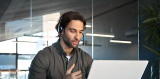 Busy,Male,Support,Service,Operator,Talking,To,Customer,Sitting,At