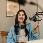Confident,Latin,Woman,With,Headphones,And,Microphone,Recording,A,Podcast