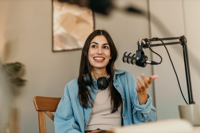 Confident,Latin,Woman,With,Headphones,And,Microphone,Recording,A,Podcast