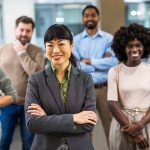 Asian,Boss,Standing,In,Front,Of,Her,Colleagues,In,The