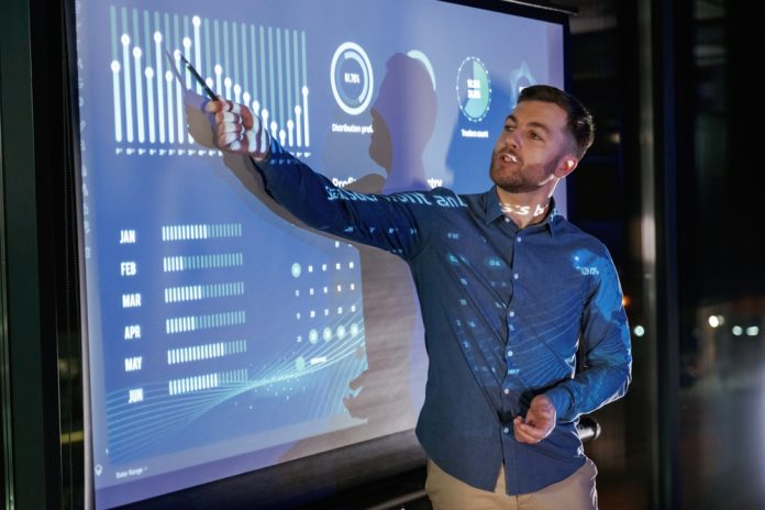 Statistics,On,The,Screen.,Business,Coach,Against,Projector,With,Data. Statistics,On,The,Screen.,Business,Coach,Against,Projector,With,Data.