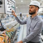 Industrial,Engineer,Wearing,Hardhat,Operating,Control,Panel,Of,Machinery,In